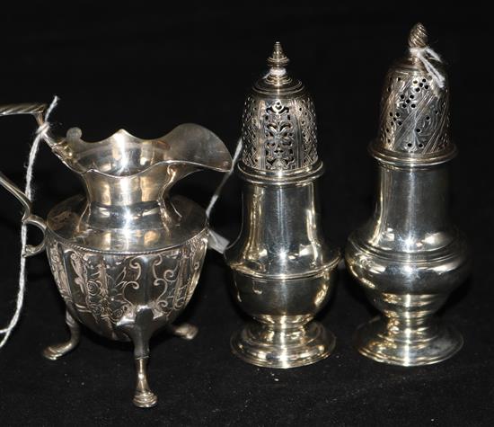 A George III silver small sugar caster, London 1776, Robert Peaston, a similar caster and a small engraved urn-shaped cream jug, 10oz